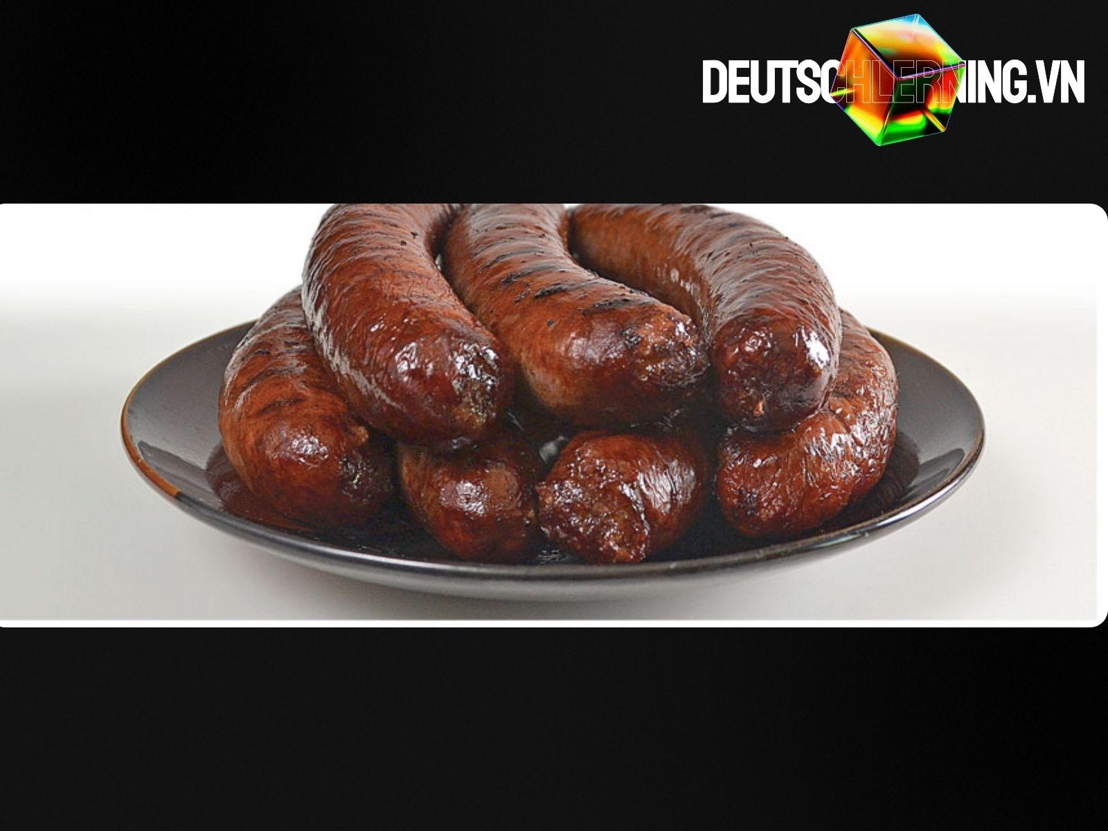 Bratwurst nướng trên vỉ than cùng bánh mì và mù tạt.