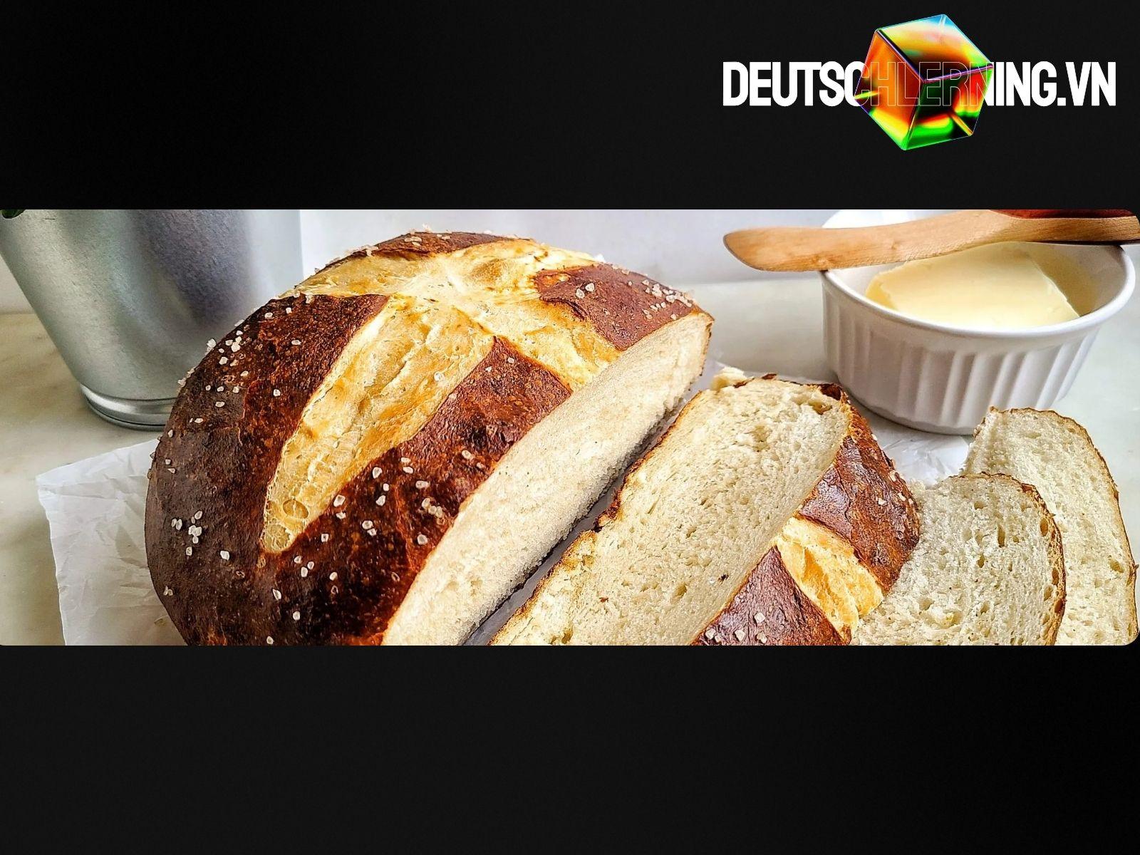 Pretzel tươi và bánh mì đen trên thớt gỗ.